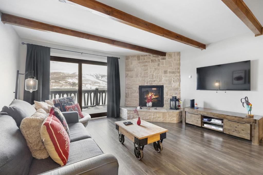 a living room with a couch and a tv at Luxury Condominium with Rustic Minimalist Style in Mont-Tremblant