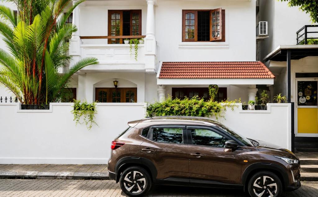 a brown car parked in front of a house at GOOD KARMA INN Apartment in Cochin
