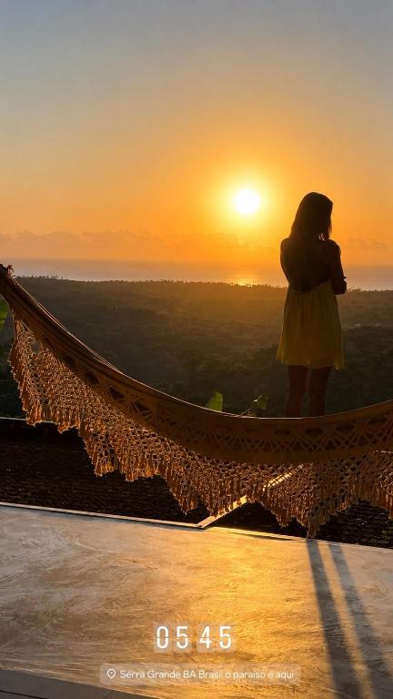a woman standing on top of a hammock watching the sunset at Fazenda 101 in Ilhéus