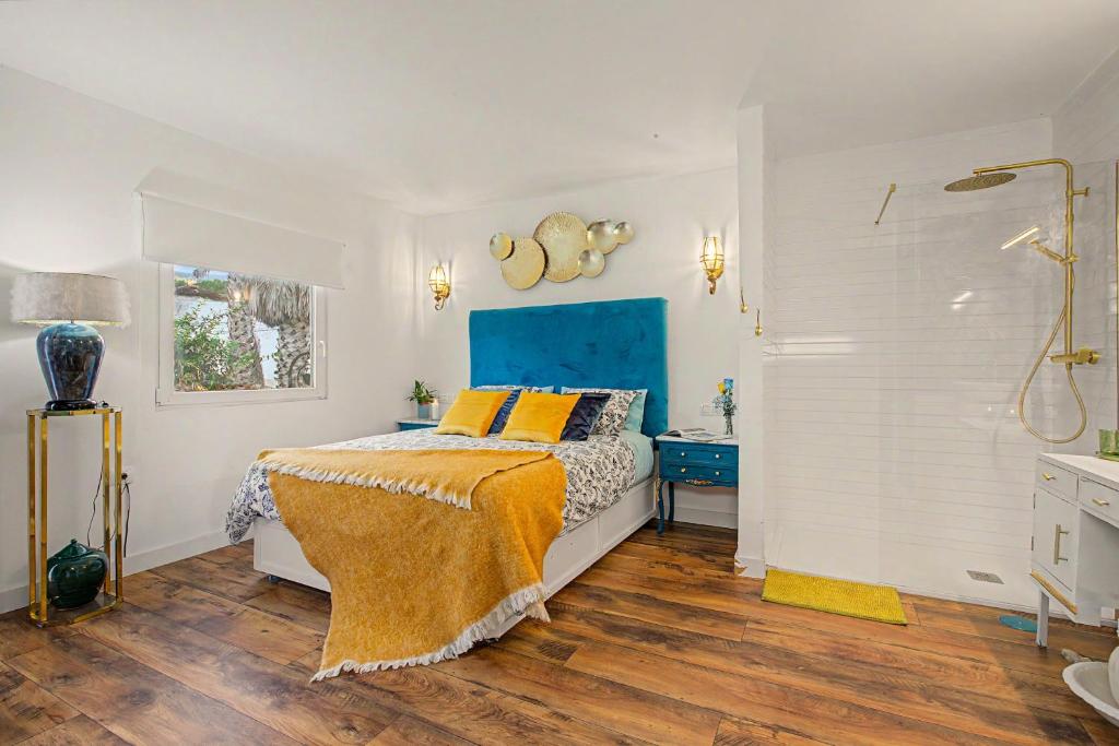 a bedroom with a bed and a blue headboard at casa Jardín del sol planta alta in Tacoronte