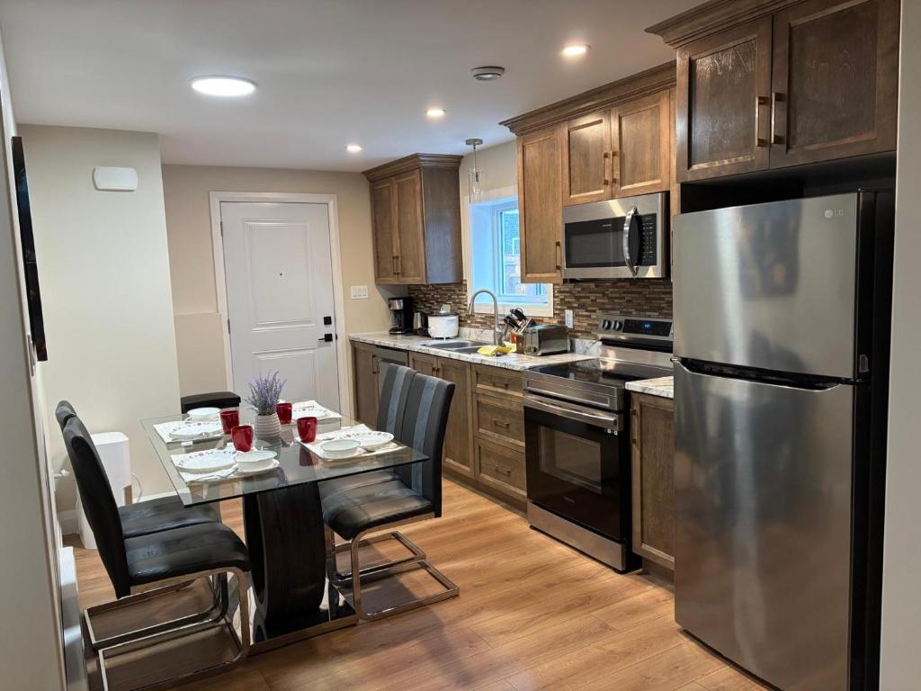 a kitchen with a table and a stainless steel refrigerator at Happy Homes in St. John's