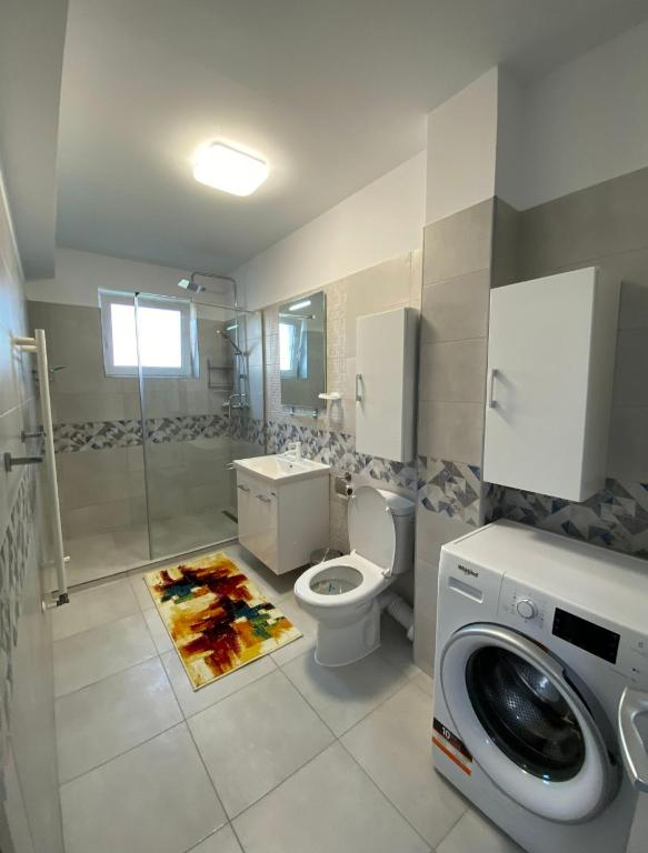 a bathroom with a toilet and a washing machine at Tomorrowland Residence in Boom