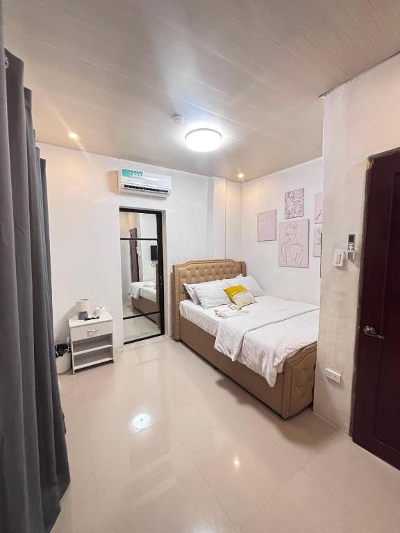 a small bedroom with a bed and a mirror at Next House Passi City in Iprog