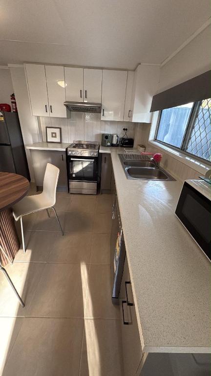 a kitchen with white cabinets and a counter top at Family Friendly One Bedroom Studio in Brisbane