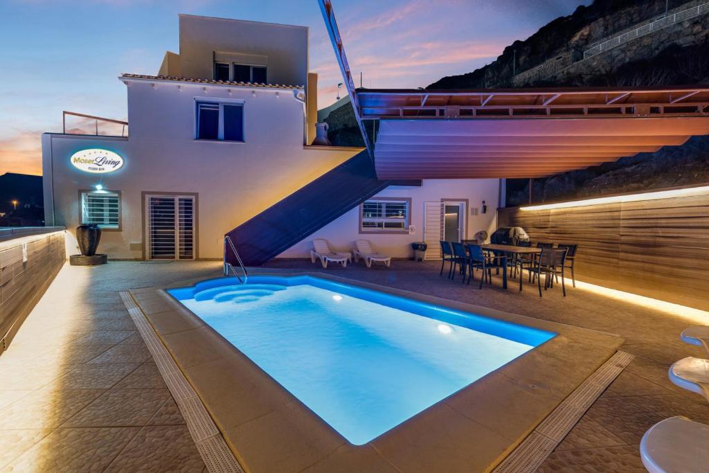 a house with a swimming pool and a staircase at Moser Living Premium Apartments - Puerto Rico in Mogán