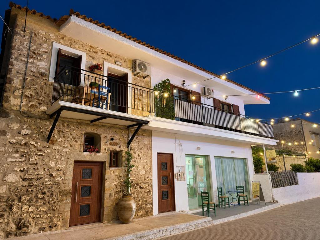 a stone house with a balcony and a patio at Markella STONE & LIGHT Skoutari-Mani in Skoutari