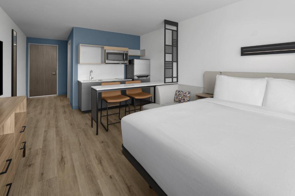 a hotel room with a bed and a kitchen at StudioRes by Marriott Clearfield Layton in Clearfield
