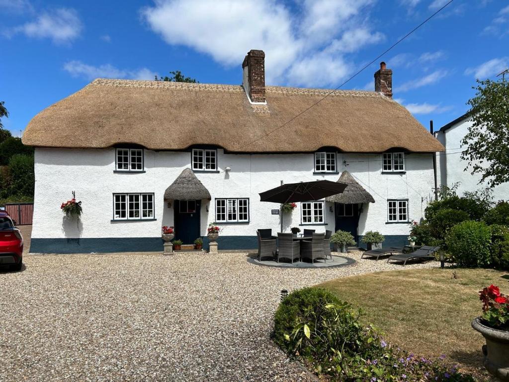 a large white house with a thatched roof at Cotford Cottage in Sidmouth