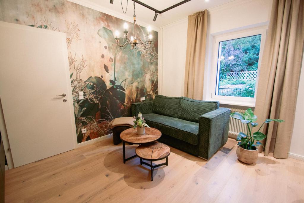 a living room with a green couch and a table at Appartement Promenadenhirsch in Bad Gastein