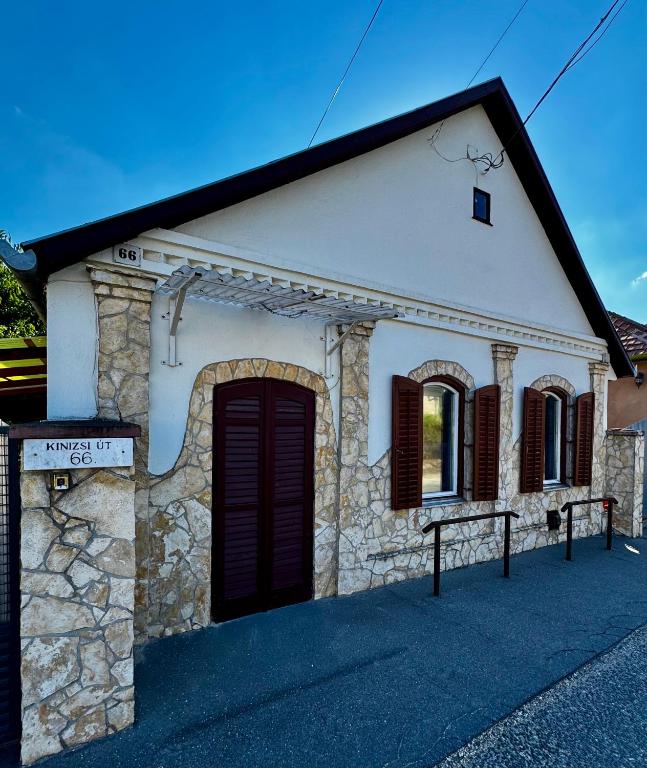 a small stone house with a black door at Kinizsi House in Szigetszentmiklós