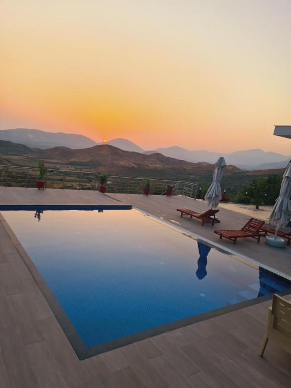 a pool with the sunset in the background at Villa Panorama - Private Swimming Pool & Parking in Sarandë