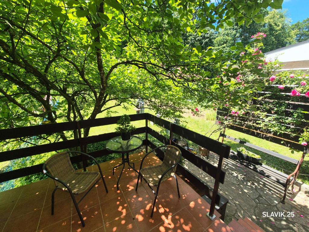 a patio with a table and chairs on a fence at Kuća za odmor SLAVIK in Daruvar