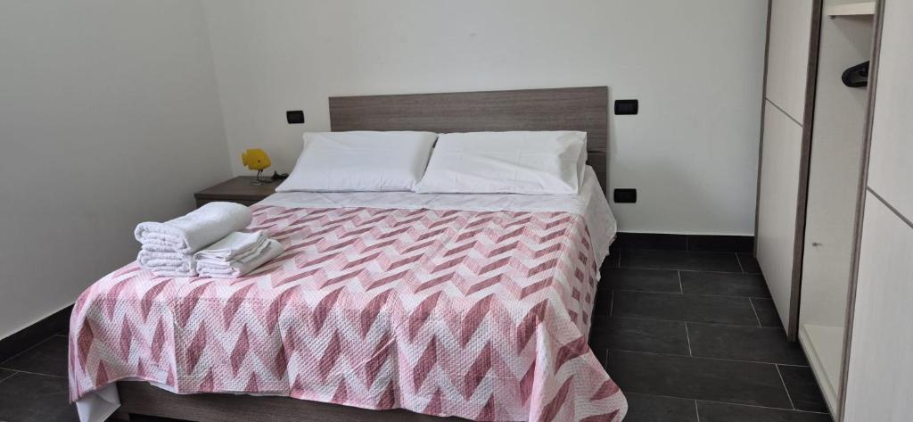 a bedroom with a bed with a pink and white blanket at Arenzano rooms in Arenzano