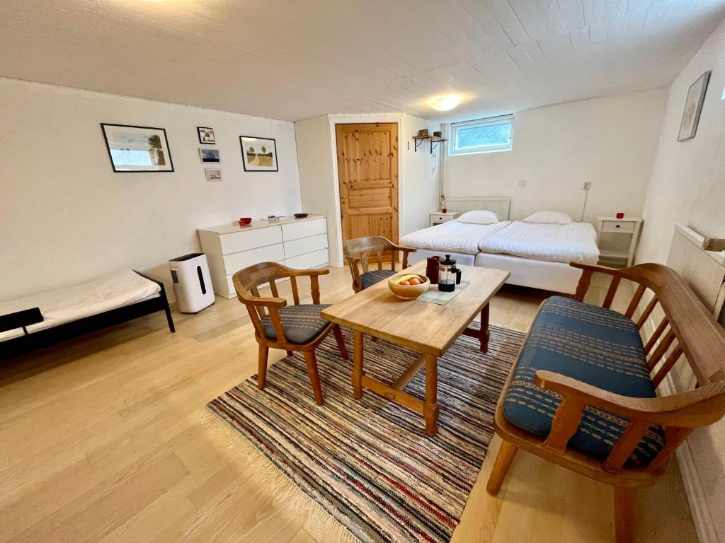 a room with a bed and a table and chairs at Villa María - Charming 40 m2 lower level suite with private entrance in Simrishamn