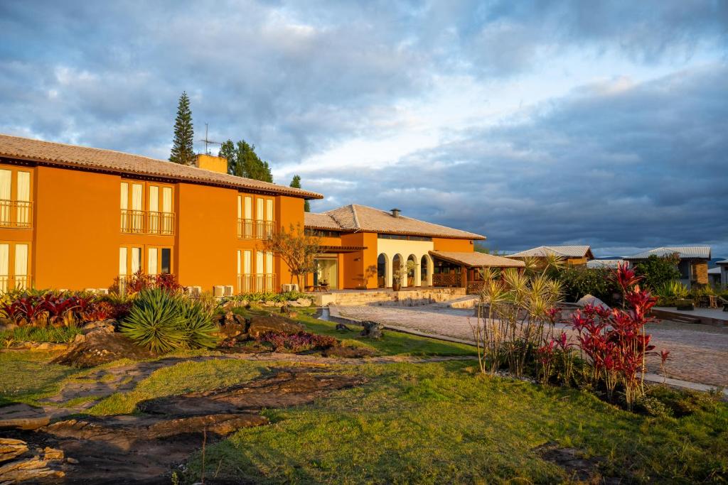 an orange building with a garden in front of it at Casarão Alpina in Mucugê