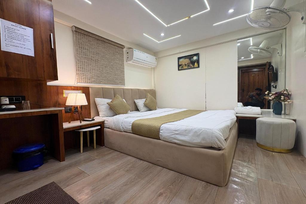 a bedroom with a large bed and a desk at Hotel Anantshree Inn Shree Mahakaleshwar Temple Ujjain in Ujjain