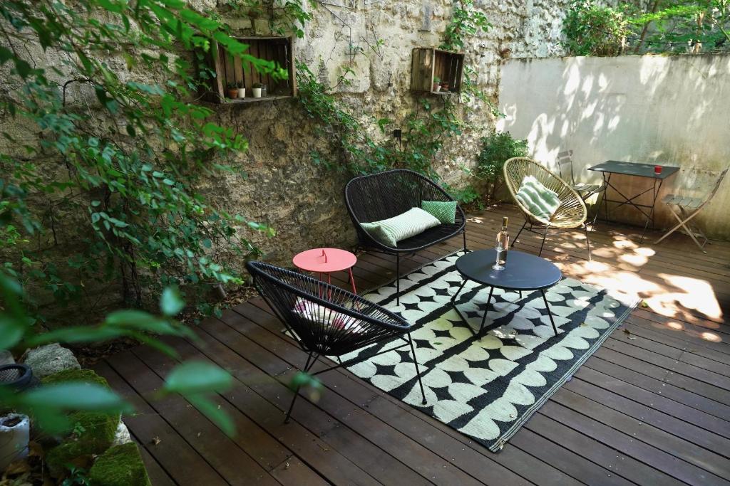 a patio with chairs and tables on a wooden deck at T2 intra muros clim et cour ombragée in Avignon