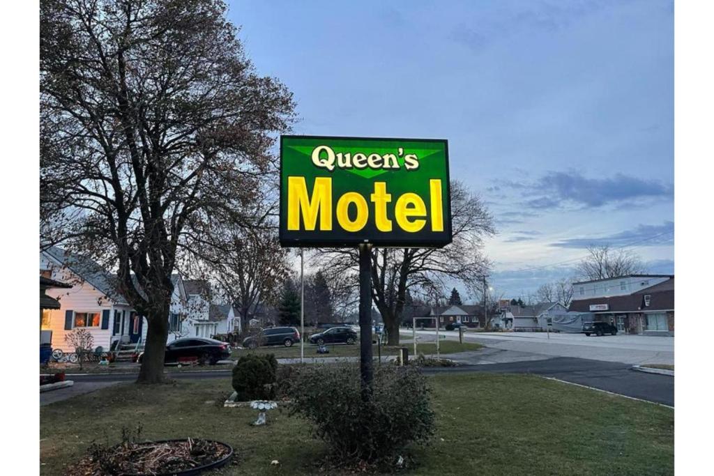 a sign for a queens motel on a street at Queen's Motel Blenheim Near Lake Erie ON in Blenheim