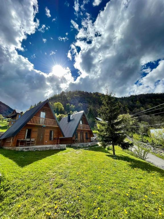 a large wooden house on a grassy field at Bujtina n'kullë in Boge