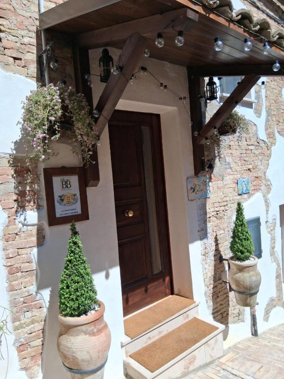 a front door of a house with two potted trees at B&B Colle Degli Angeli in Penne