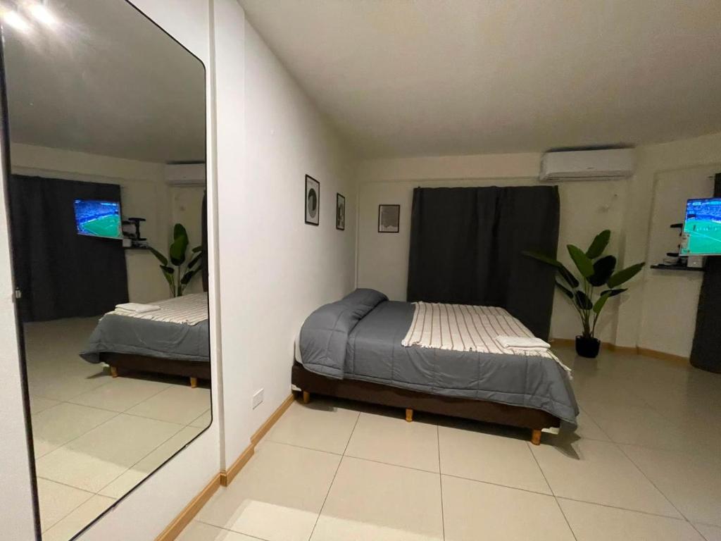 a bedroom with two beds and a large mirror at Apart Escobar in Belén de Escobar