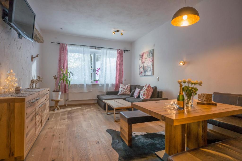 ein Wohnzimmer mit einem Sofa und einem Tisch in der Unterkunft Berghof Haselsberger Appartements in Sankt Johann in Tirol