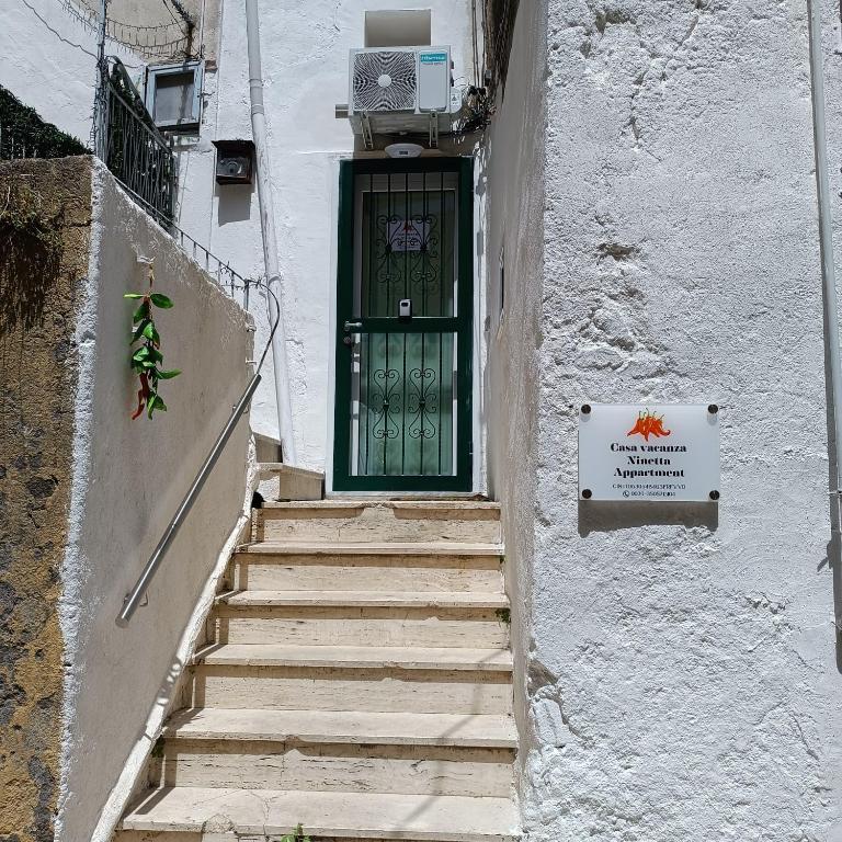 a stairway leading to a green door in a building at Casa Ninetta in Pimonte