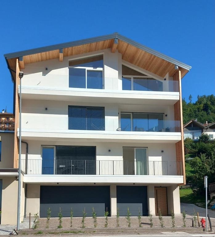 an apartment building with a white facade at Riflessi sul lago in Baselga di Pinè