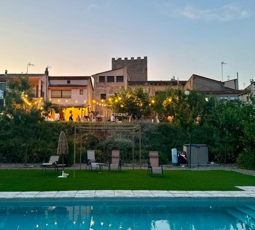 a swimming pool with chairs and a building in the background at Castillo de Bulbuente de Luis Zueco in Bulbuente