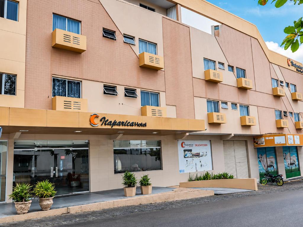 a large pink building with windows and plants at Hotel Itaparica in Caruaru