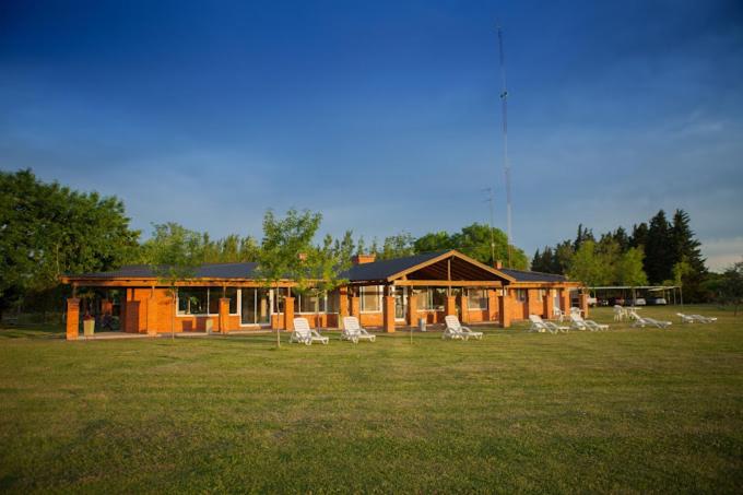 a group of chairs sitting in front of a cabin at La Chacra Hotel Campo y Spa in San Pedro