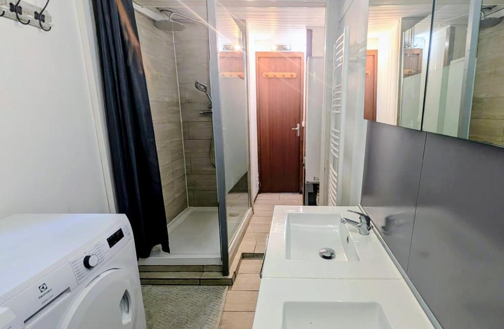 a white bathroom with a sink and a shower at La carrouere in Gujan-Mestras