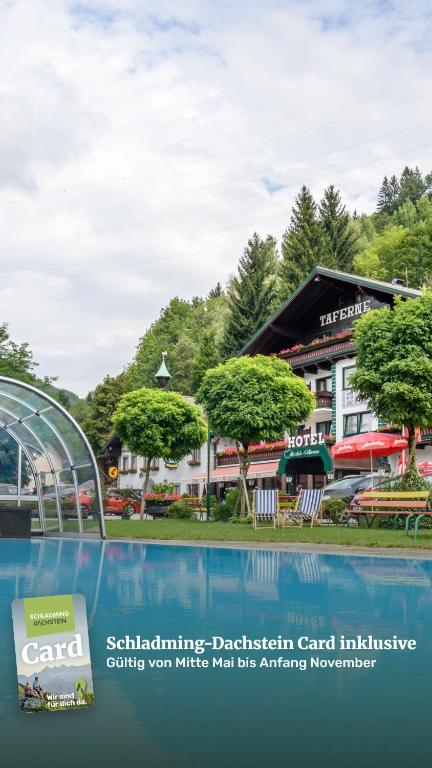 a sign next to a swimming pool in front of a building at Hotel & Gasthof Taferne in Schladming