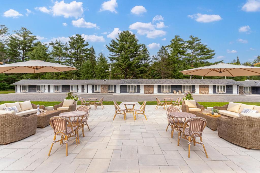 a patio with chairs and tables and umbrellas at Sand and Stone Resort in Huntsville
