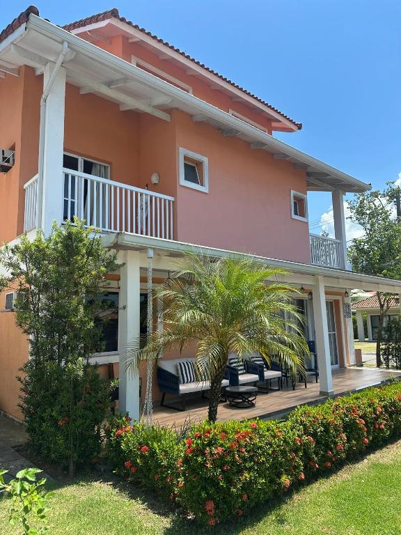 a house with a patio and palm trees at Village Ducado in Mangaratiba