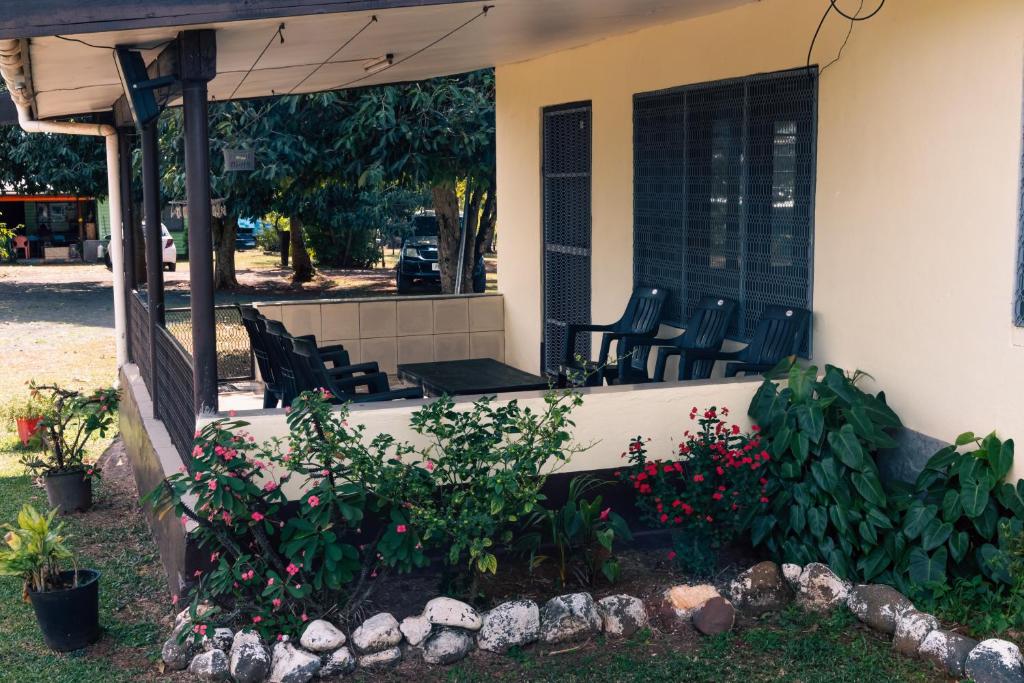 a porch of a house with chairs and flowers at Tovuka House Scuba too in Rakiraki