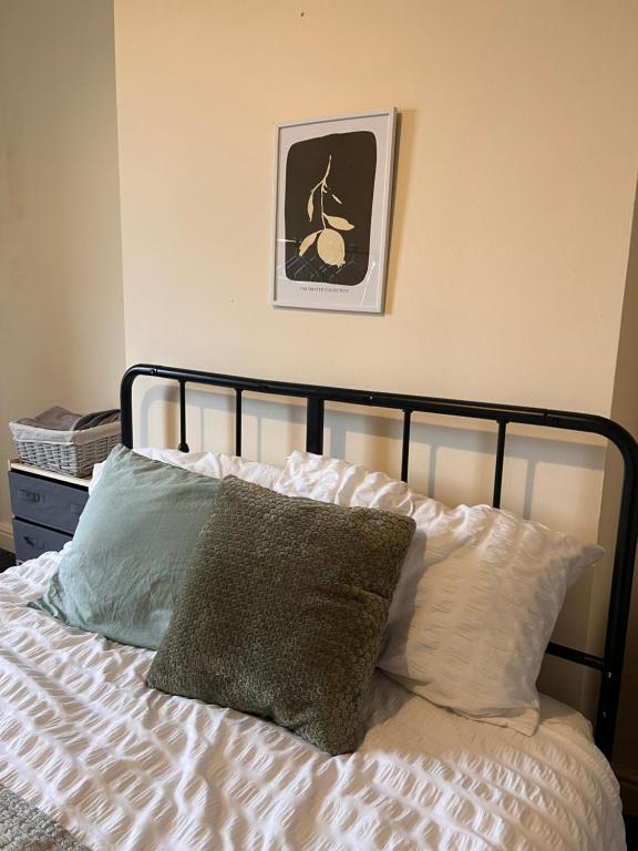 a bed with two pillows and a picture on the wall at The Blackburn 2 Bedroom House in Cherry Tree
