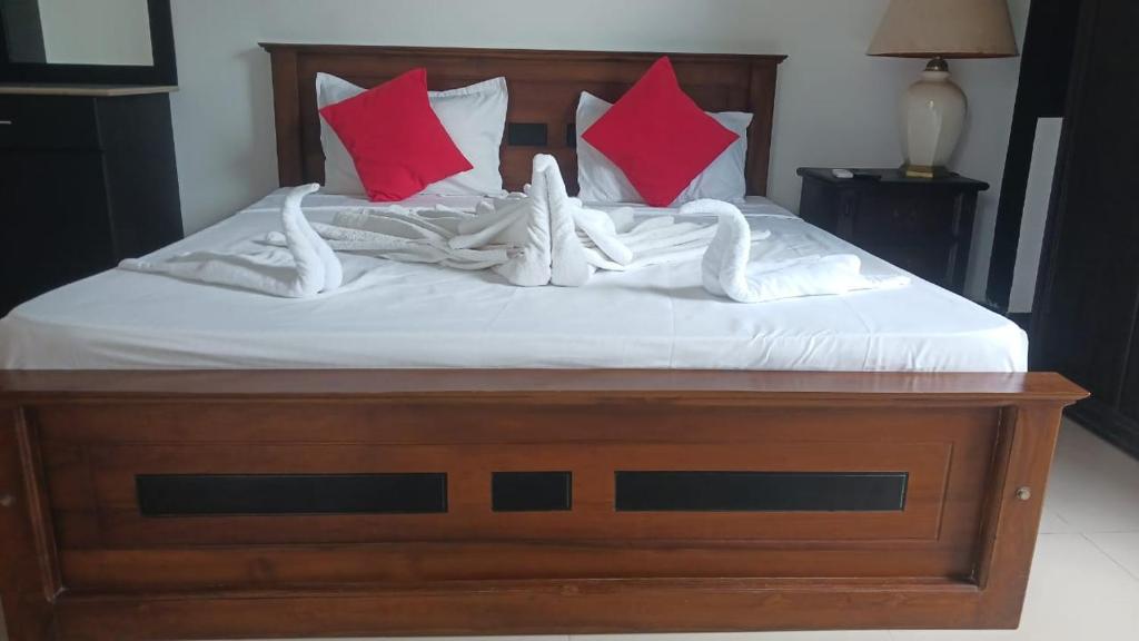 a bed with red and pink pillows on it at Kenrish Hotel in Wadduwa
