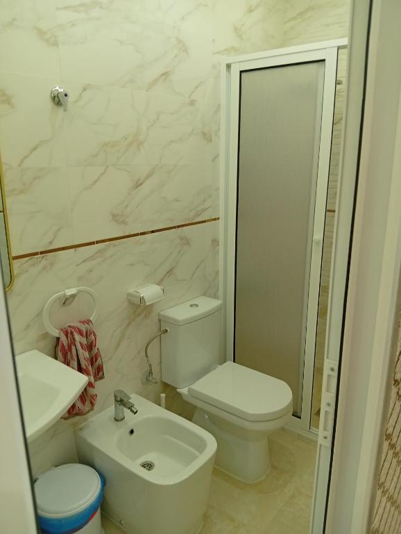a white bathroom with a toilet and a sink at BENYOUNECh in Belyounech 