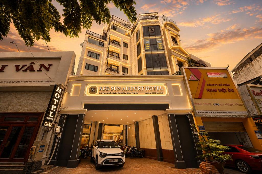 a white car parked in front of a building at Red Sun Airport Saigon Hotel in Ho Chi Minh City