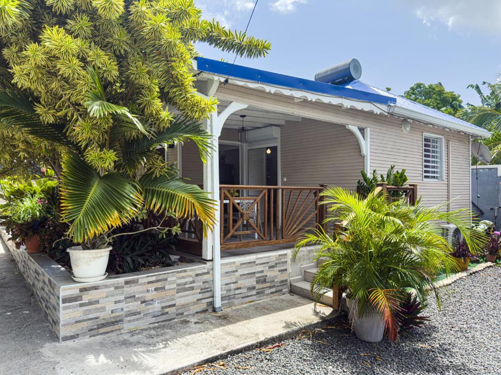 a small house with a porch and a deck at Edenbluetropical in Le Moule