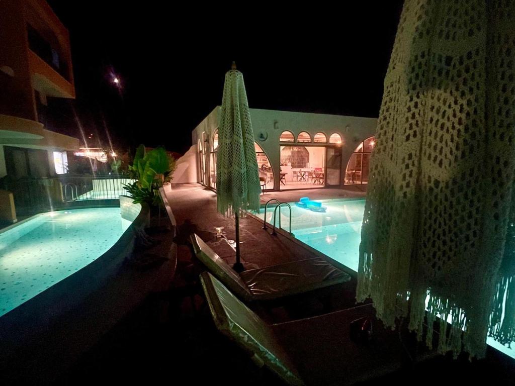 an outdoor swimming pool at night with a umbrella at Lina Life in Fethiye