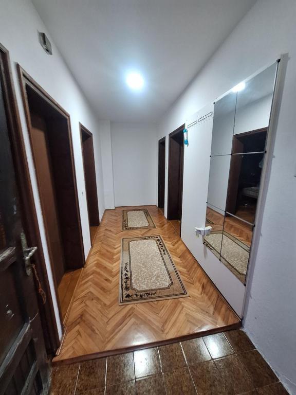 a hallway with wooden floors and a door with a mirror at Radnicki smestaj in Prilike