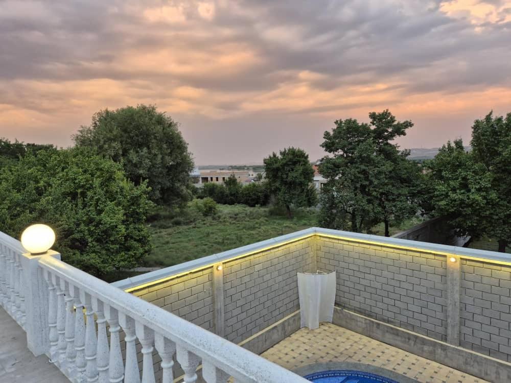 a balcony with a white railing and a blue pool at Villa by HomeLand in Khujand