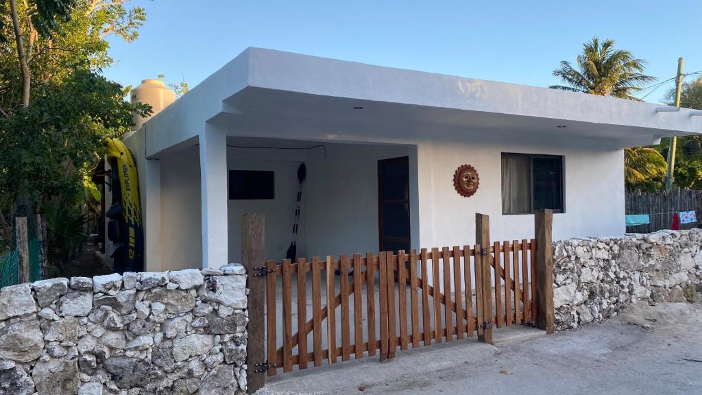 a small house with a stone wall and a fence at El Sol del Cuyo in El Cuyo
