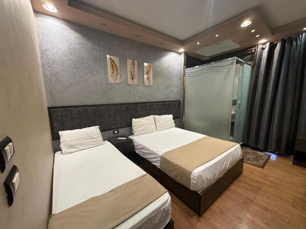 a bedroom with two beds and a shower at Cairò Plàza, Ravexa Hotel in Cairo
