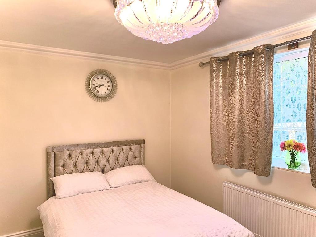 a bedroom with a bed and a chandelier at Williton Guest House in Luton