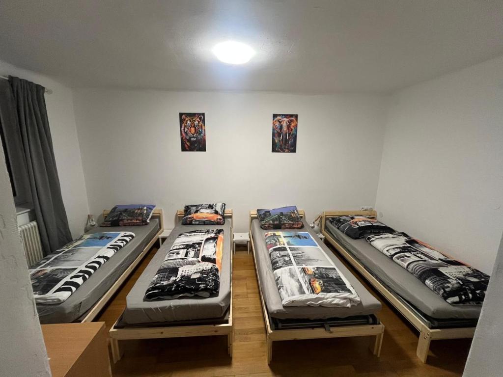 three beds are lined up in a room at Gästehaus JaWo in Neuruppersdorf
