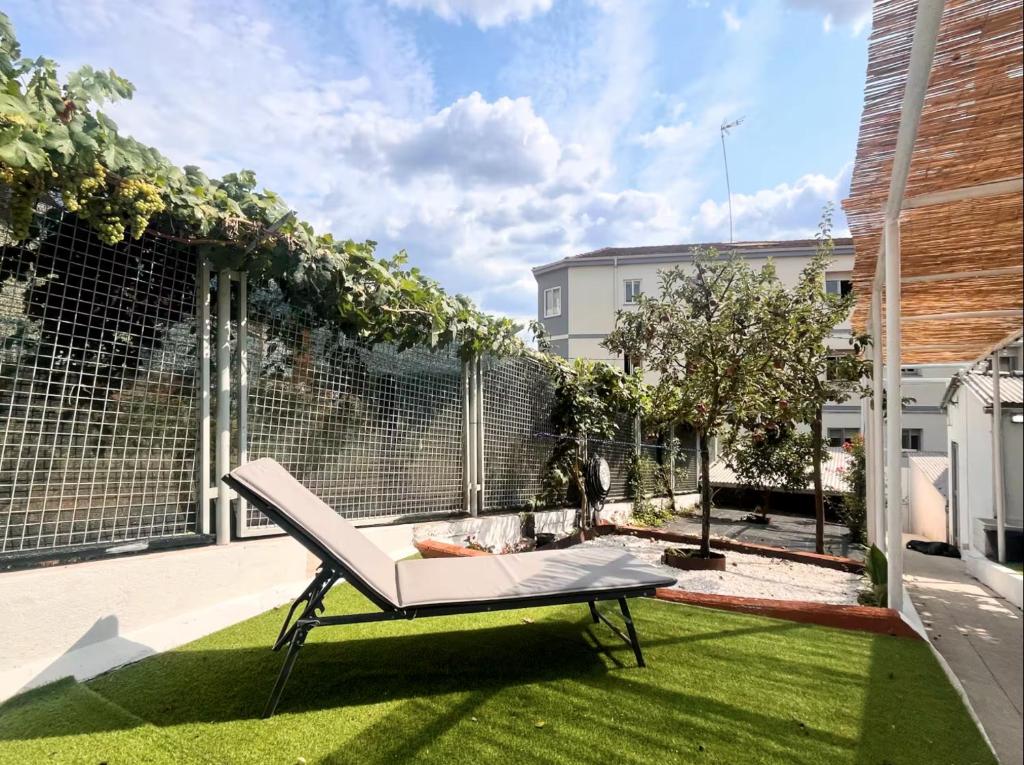 a small garden with a bench on the grass at Casa Pepe in Ourense