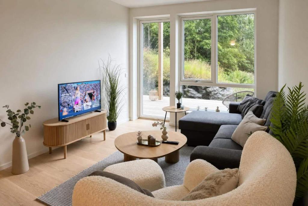 a living room with a couch and a tv at The Haven II - Cozy 2BR Voss - The Voss Collection in Vossevangen